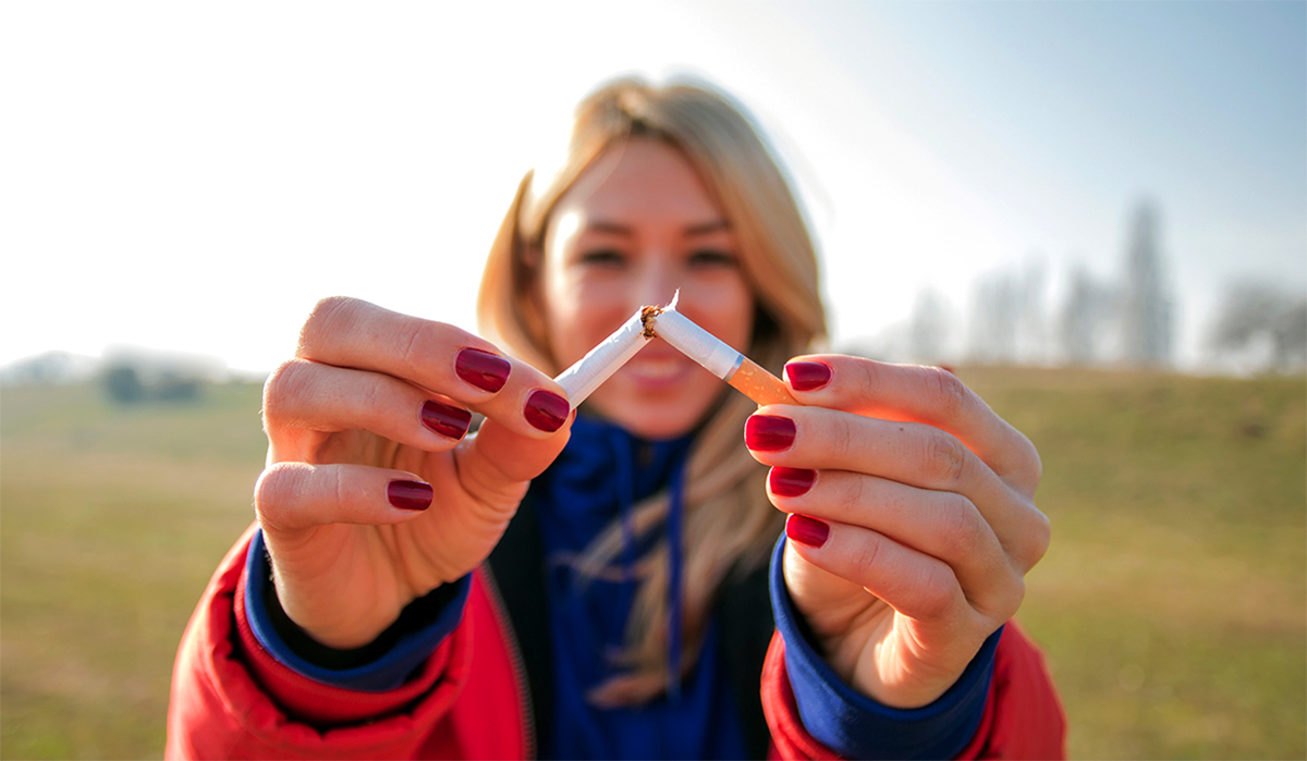 A person breaking a cigarette in half