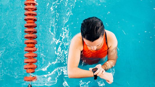A person checking her watch in a swimming pool