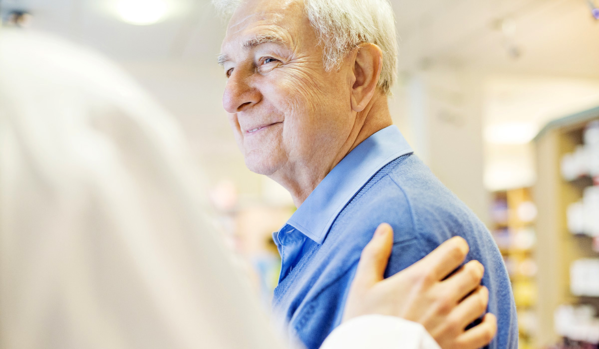 A pharmacist consoling a senior customer