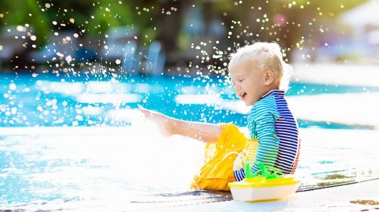 A child playing with water in the sun