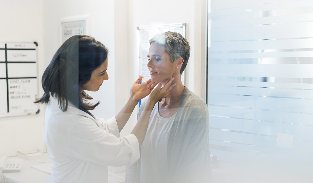 A doctor examining her patient's thyroid glands