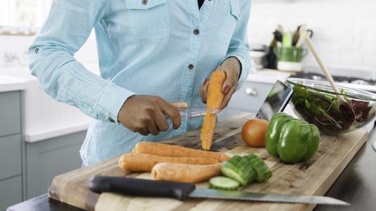 A person peeling carrots in the kitchen