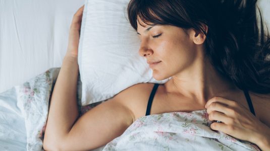 A person sleeping comfortably in her bed