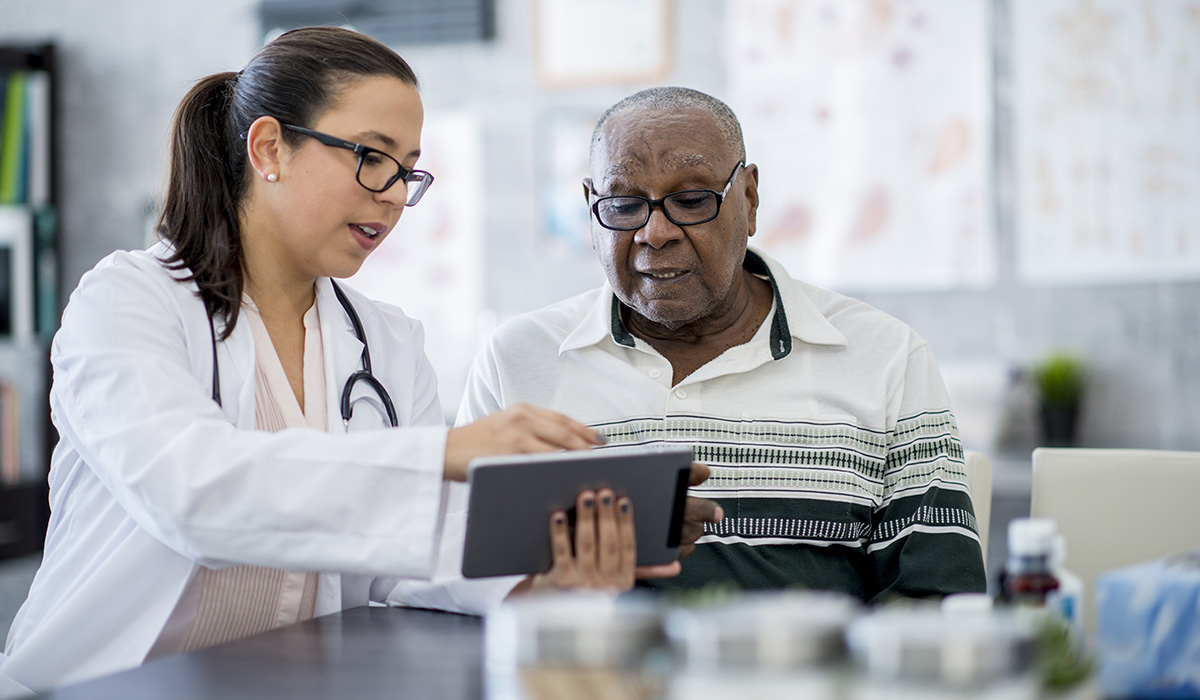 A doctor using a tablet computer to show her patient information