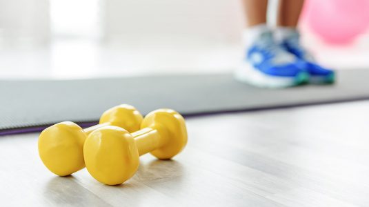 Yoga mat with yellow dumbells