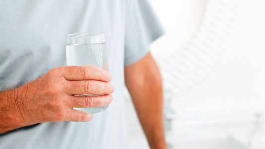 A person holding a glass of water