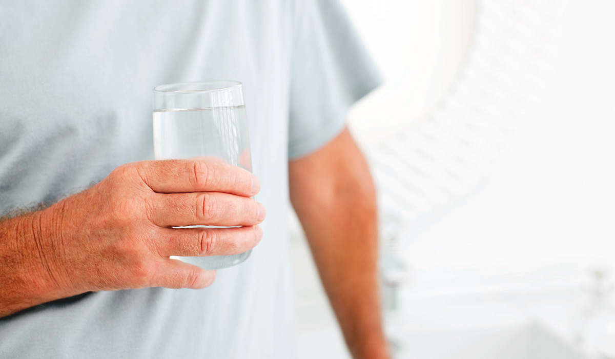 A person holding a glass of water