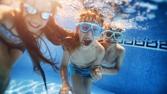 Kids playing under water in swimming pool