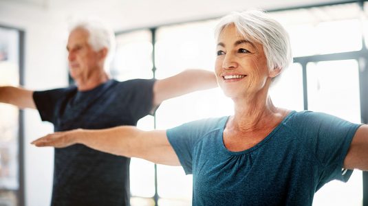 A senior couple exercising together indoors