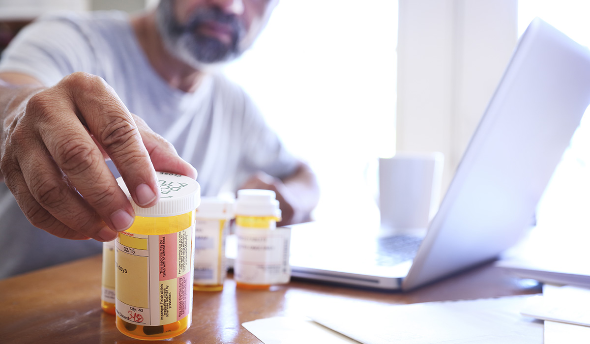 A person reaching out for his prescription medicine