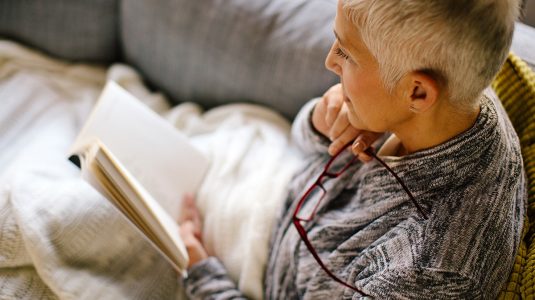 A person reading a book at home