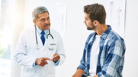 A doctor having a discussion with his young male patient
