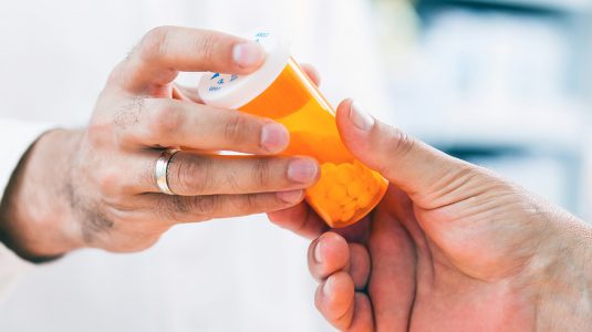 pharmacist giving pills to customer