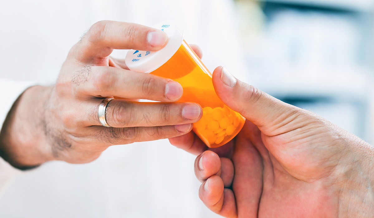 pharmacist giving pills to customer
