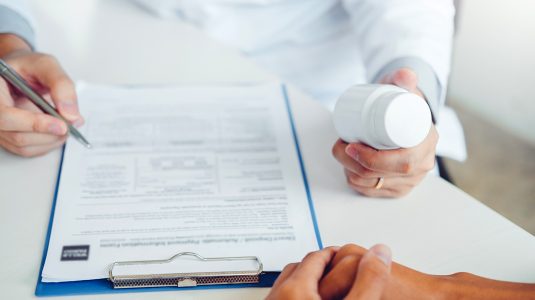 Doctor handing medication to patient
