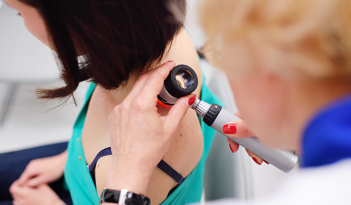 doctor examining birthmarks and moles on a patient