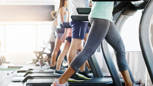 A group of people exercising on treadmills in a gym