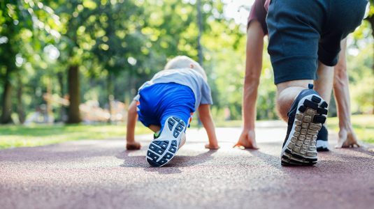young boy and his father stretching outdoors
