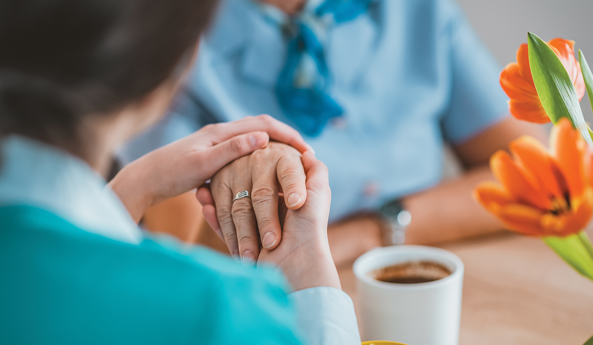 A person holding a senior's hand