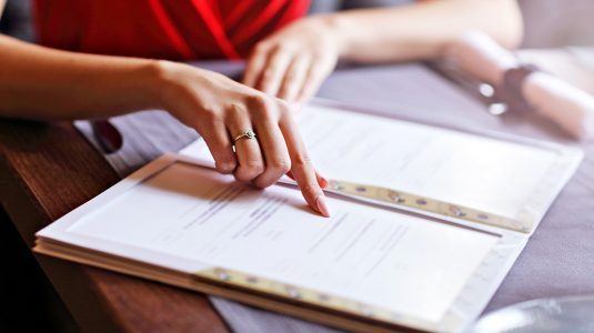 A person reading a menu at a restaurant