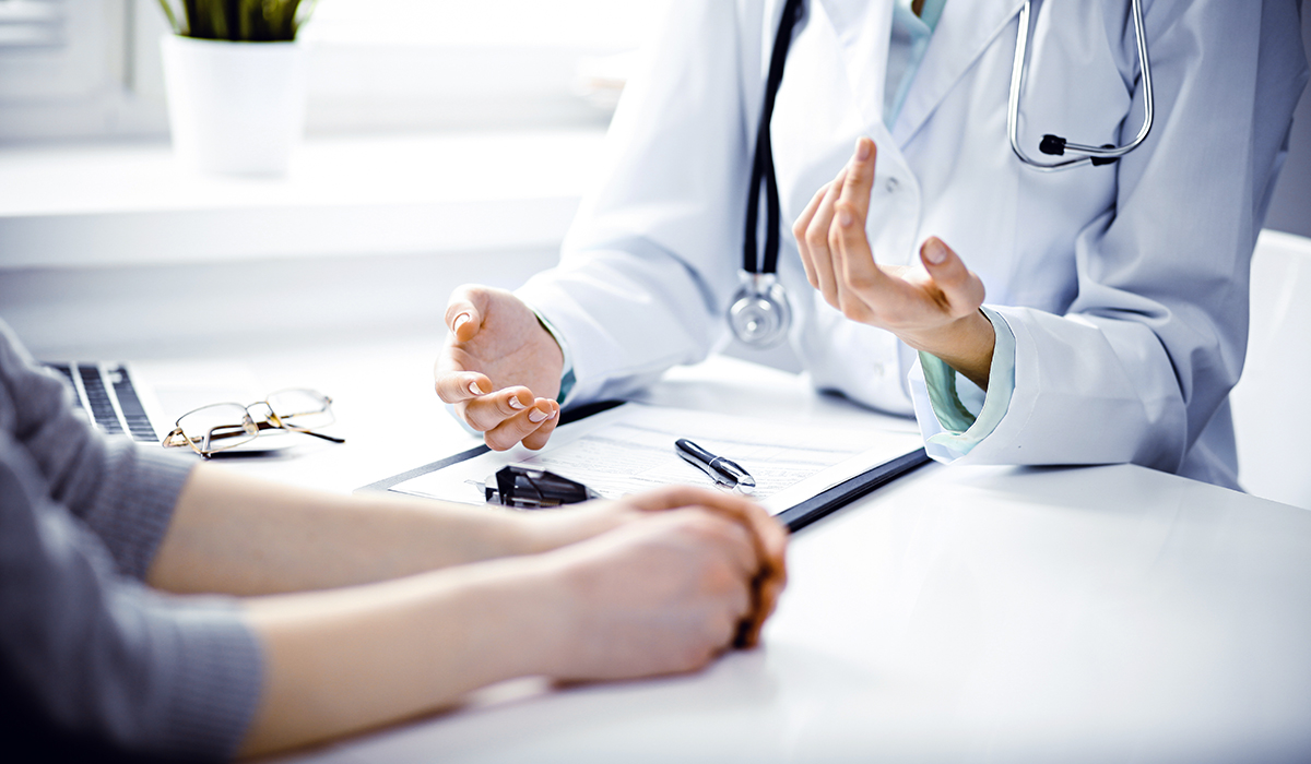 A doctor and a patient sitting at a desk while talking