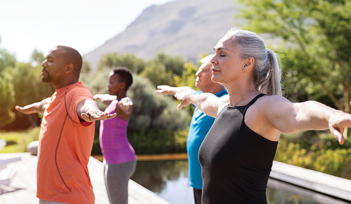 Group of people practicing yoga and breathing outdoors