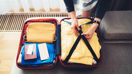Closeup of a person packing their luggage for travel