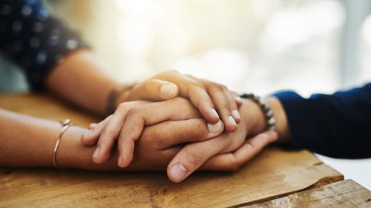 A closeup shot of two people holding hands