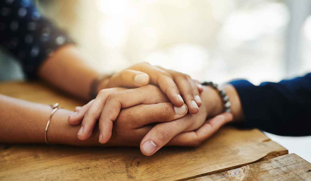 A closeup shot of two people holding hands
