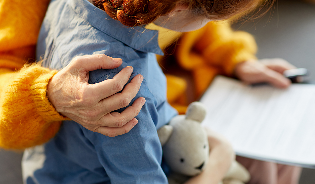 A closeup of an older woman hugging a teenage girl