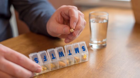 Man using a pill holder for daily meds