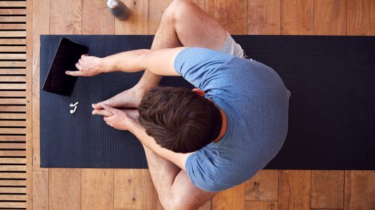 Man sitting on an exercise mat