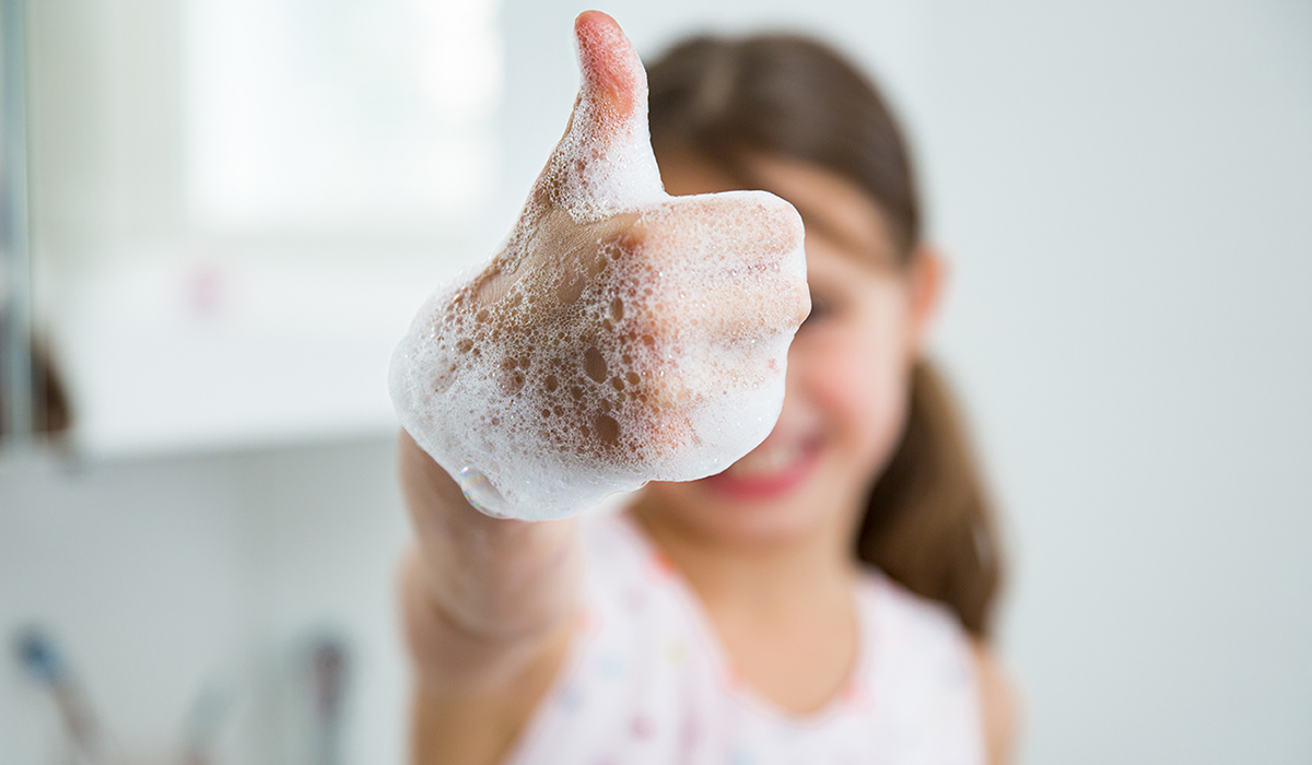 Little girl washing hands with water and soap
