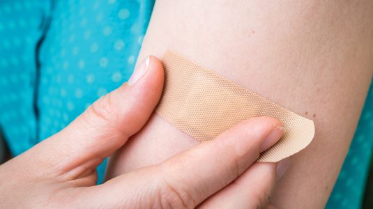A person putting on a bandaid