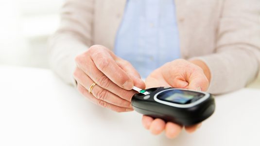 A senior woman with glucometer checking blood sugar