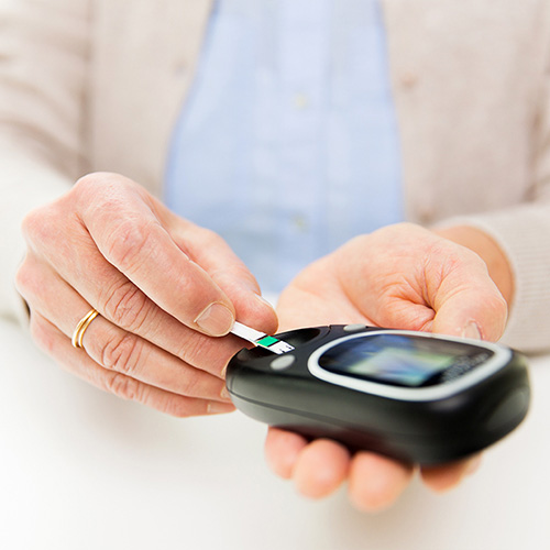 A senior woman with glucometer checking blood sugar