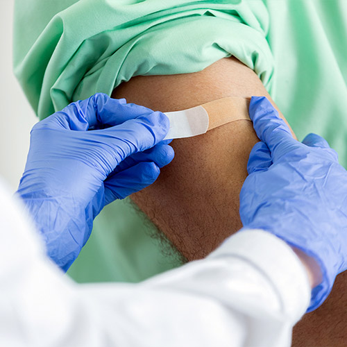 Pharmacist places a bandaid on a customer's arm after immunization.jpg